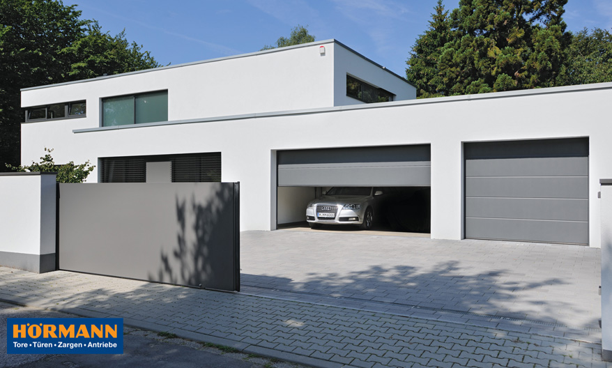 Garagentore eines modernen Wohnhauses öffnen sich, damit Auto ausparken kann