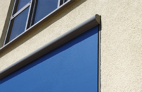 Ausschnitt Nahaufnahme einer Gebäudefront mit blauer Senkrechtmarkise
